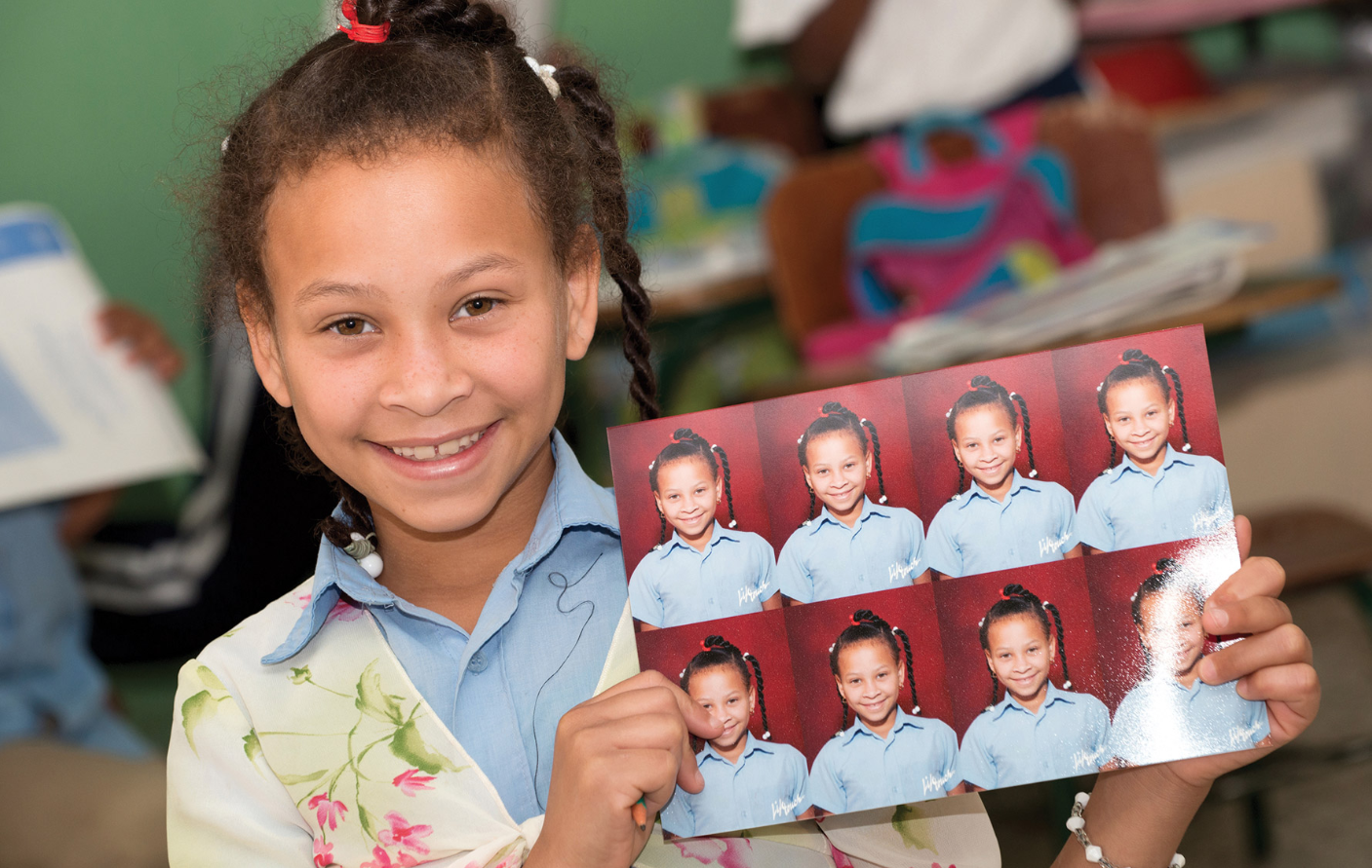 Memory Mission Program - Little girl holding school images from memory mission